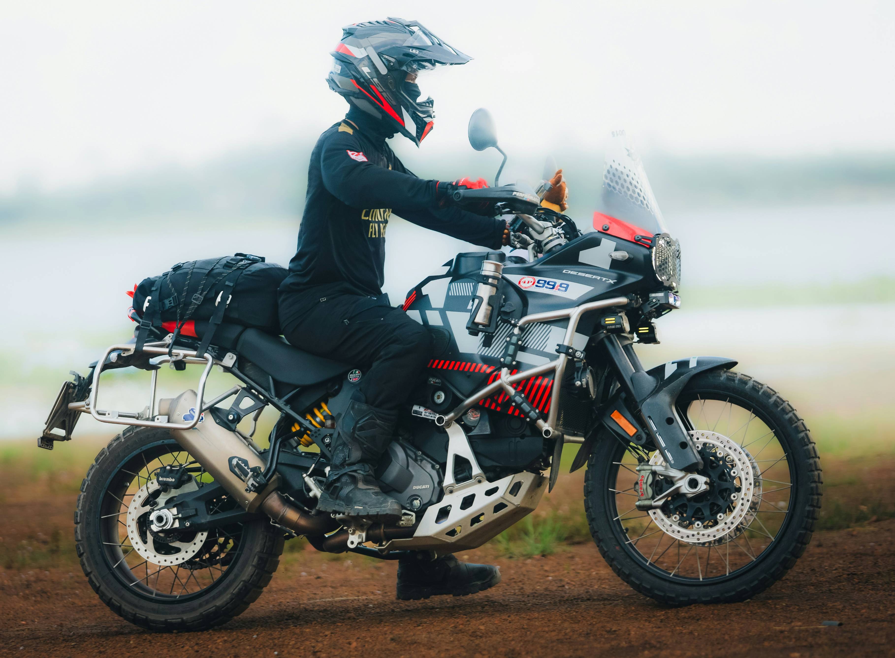 Rider on a motorcycle with luggage by water
